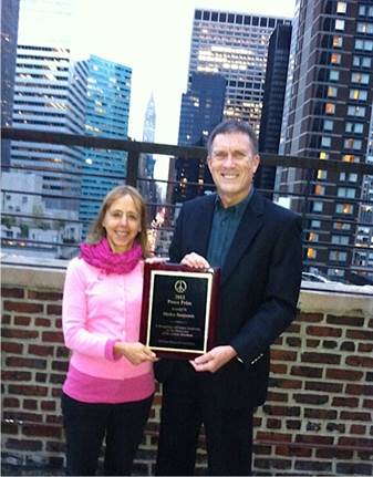 A person and person holding a plaque

AI-generated content may be incorrect.